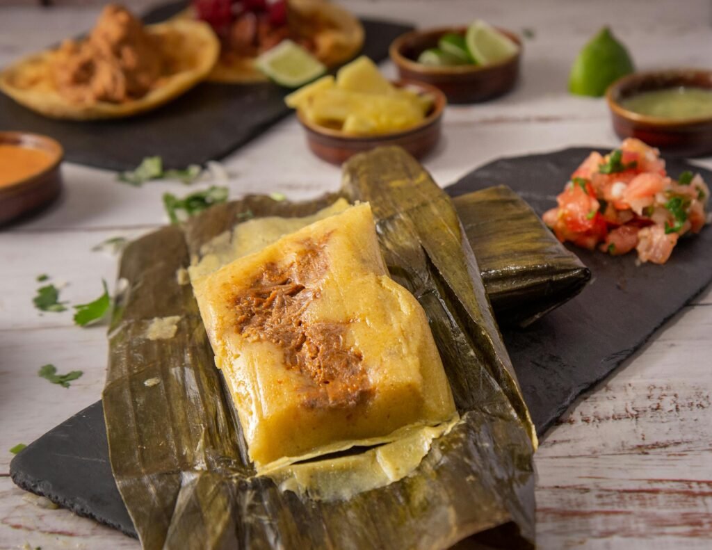 Discover the rich flavors of this traditional Mexican tamale served with salsa on a rustic wooden table.